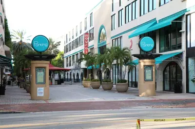 an empty city street with buildings and palm trees at Amazing Studio - Walking Distance To Cocowalk in Miami