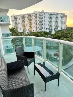 a balcony with chairs and tables and a building at SPECIAL Beautiful Modern Beach Condo in Miami Beach