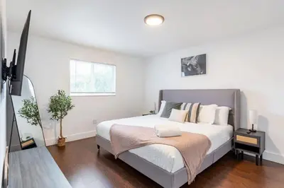 a white bedroom with a bed and a television at Cozy Miami Home Pet-friendly & with Free Parking in Miami
