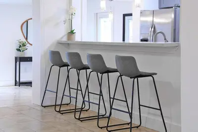 a kitchen with a bar with four stools at Cozy Miami Home Pet-friendly & with Free Parking in Miami