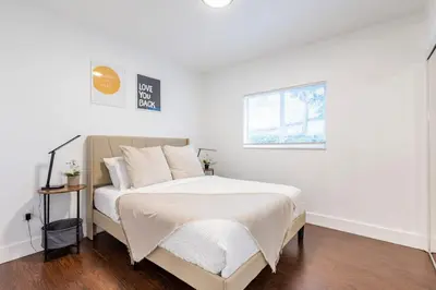 a bedroom with a bed with white sheets and a window at Cozy Miami Home Pet-friendly & with Free Parking in Miami
