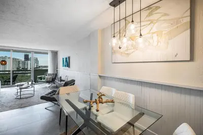 a dining room with a glass table and chairs at LUXURY APARTMENT - Direct Bay in South Beach in Miami Beach
