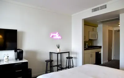 a room with a bed and two bar stools at Stunning 12th Floor Studio In The Heart Of Grove in Miami