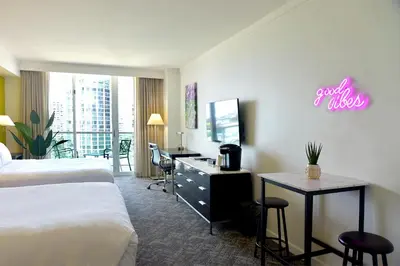 a hotel room with two beds and a desk at Stunning 12th Floor Studio In The Heart Of Grove in Miami