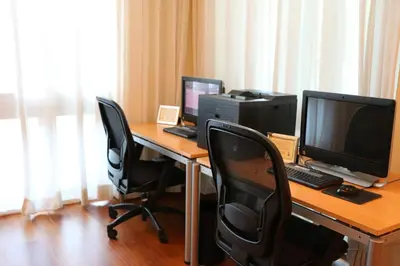 a desk with two monitors and a computer on it at Stunning 12th Floor Studio In The Heart Of Grove in Miami