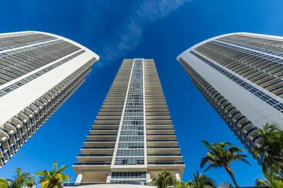 two tall buildings against a blue sky with palm trees at Splendid Resort - Oceanview 1BDR & 1BA Apt Right on the Beach, Heated pool, GYM in Hollywood