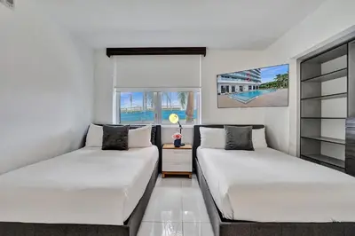 two beds in a room with a window at Upscale Resort 4 Bedrooms 3 Bath in Hallandale Beach