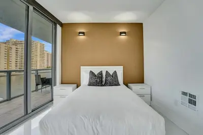 a bedroom with a white bed and a large window at Upscale Resort 4 Bedrooms 3 Bath in Hallandale Beach