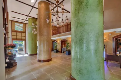 a large lobby with columns and a chandelier at Treetop Retreat! Cozy 2 Bedroom In Heart Of Grove in Miami