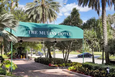 a sign for the mutiny hotel in a parking lot at Treetop Retreat! Cozy 2 Bedroom In Heart Of Grove in Miami