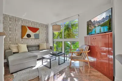 a living room with a couch and a table at Treetop Retreat! Cozy 2 Bedroom In Heart Of Grove in Miami
