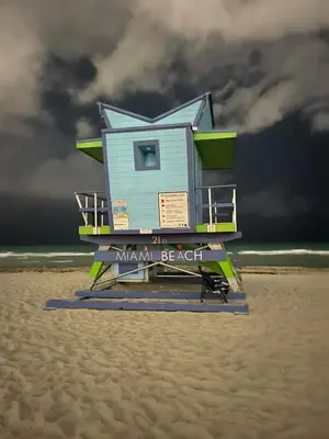 a blue lifeguard house on the beach with a storm at OQP Vacations in Miami