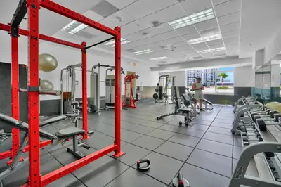 a man standing in a gym with red equipment at Zeus' Sanctuary Ocean View In Brickell Miami in Miami