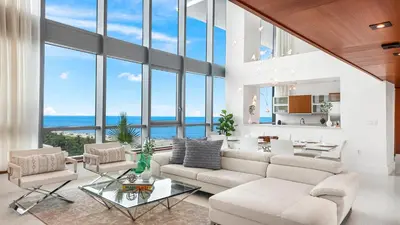 a living room with a white couch and chairs and windows at Oceanview Private Townhouse at The Setai 1505-THB in Miami Beach