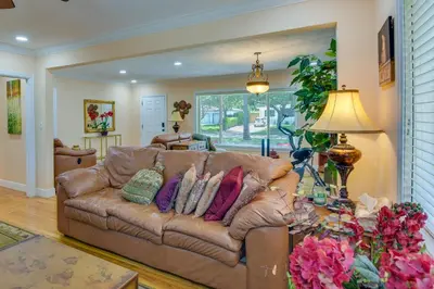 a living room with a brown leather couch with pillows at El Portal Vacation Rental about 9 Mi to Miami! in Miami