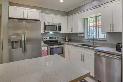 a kitchen with white cabinets and stainless steel appliances at El Portal Vacation Rental about 9 Mi to Miami! in Miami