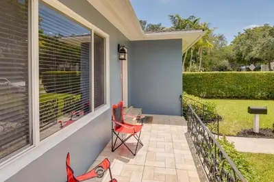 a patio with a red chair and a window at El Portal Vacation Rental about 9 Mi to Miami! in Miami