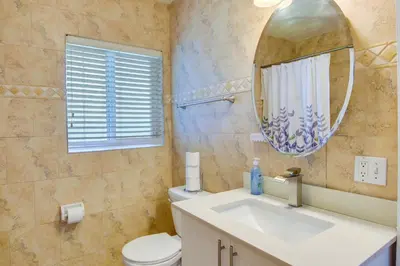 a bathroom with a sink and a mirror and a toilet at El Portal Vacation Rental about 9 Mi to Miami! in Miami