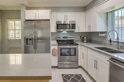 a kitchen with white cabinets and stainless steel appliances at El Portal Vacation Rental about 9 Mi to Miami! in Miami