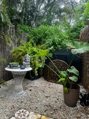 a garden with a table and some plants and a fence at Flora's Garden Apartment/Studio in North Miami