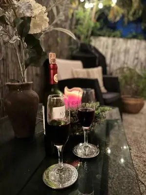 two glasses of wine on a table with a bottle of wine at Flora's Garden Apartment/Studio in North Miami