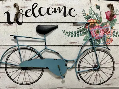 a blue bike hanging on a wall with the word welcome at Flora's Garden Apartment/Studio in North Miami