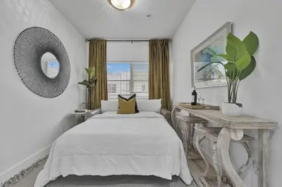 a bedroom with a bed and a table and a window at SOBE MONARCH 2 - 2 Bedroom 2 Bathroom Apts - 2 Independent 1 bedrooms apts in Miami Beach