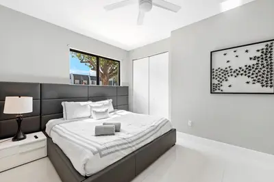 a white bedroom with a large bed and a window at Granada Modern Luxury in Massive Mansion with Heated Pool in Miami