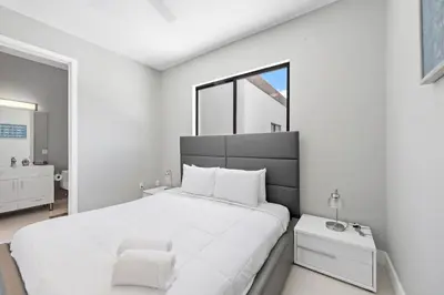 a white bedroom with a large bed and a window at Granada Modern Luxury in Massive Mansion with Heated Pool in Miami