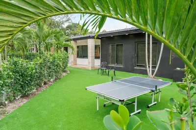 a ping pong table in the middle of a yard at VillaKoBo Heated Pool Spa Bar Tennis Golf in Miami