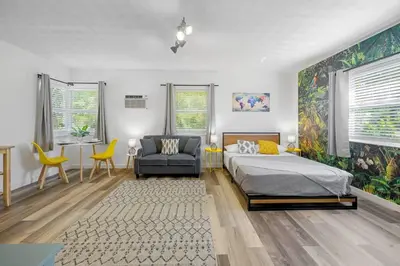 a bedroom with a bed and a chair and a desk at New stylish open space: fast Wii-fi and parking in Fort Lauderdale