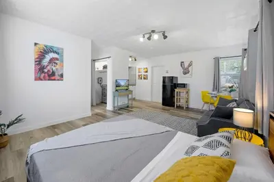 a bedroom with a bed and a living room at New stylish open space: fast Wii-fi and parking in Fort Lauderdale