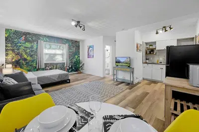 a living room with a couch and a tv at New stylish open space: fast Wii-fi and parking in Fort Lauderdale