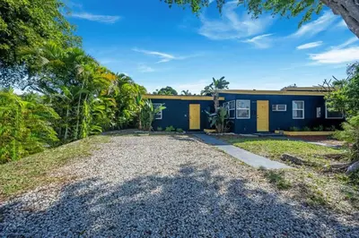 a blue and yellow house with a gravel driveway at New stylish open space: fast Wii-fi and parking in Fort Lauderdale