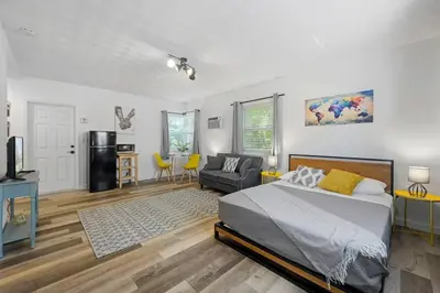 a bedroom with a bed and a living room at New stylish open space: fast Wii-fi and parking in Fort Lauderdale