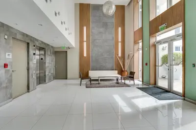 a lobby of a hospital with a bench and tables at Miami Beach Vacation Rental with Rooftop Pool Access in Miami Beach