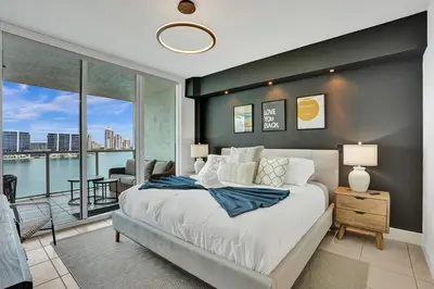 a bedroom with a large bed and a balcony at Marina Bay Sunny Isles 1005 in Miami Beach