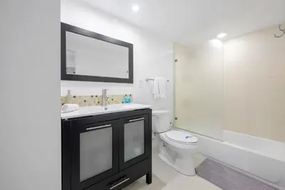 a bathroom with a sink and a toilet and a mirror at Spacious apartment of 2BR - 2BTH near of the beach great price in Miami Beach