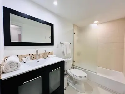 a bathroom with a sink and a toilet and a mirror at Spacious apartment of 2BR - 2BTH near of the beach great price in Miami Beach