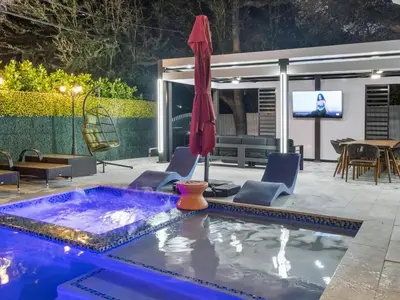 a pool with a table and chairs and an umbrella at VillaLee Luxury Heated Pool & Spa Sauna Golf in North Miami