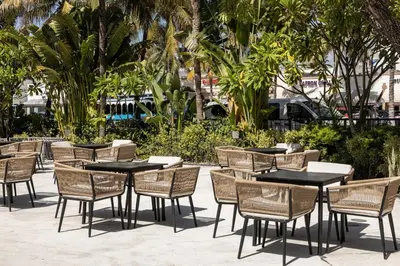 a group of tables and chairs in a courtyard at Kenmore Village Hotel, South Beach in Miami Beach