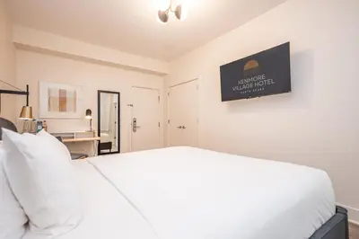 a bedroom with a white bed and a desk at Kenmore Village Hotel, South Beach in Miami Beach