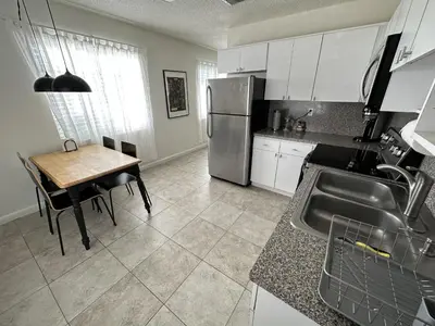 a kitchen with a table and a stainless steel refrigerator at Miami's Cozy Tropical Getaway in Miami