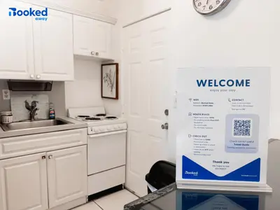 a white kitchen with a welcome sign on the door at Steps to the beach! in Miami Beach