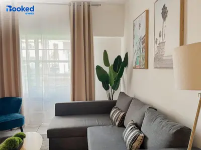 a living room with a gray couch and a window at MIAMI BEACH HOME NEAR THE OCEAN in Miami Beach