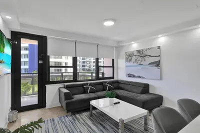 a living room with a couch and a table at Modern Miami Beach Condo with Beach Service & Pool in Miami Beach