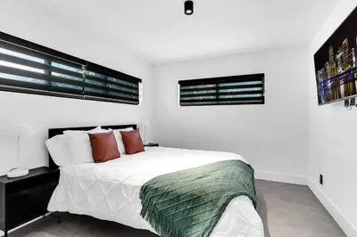 a white bedroom with a bed and a window at Heated Pool Modern 5 Bedrooms House 10 minutes to the Ocean in Miami
