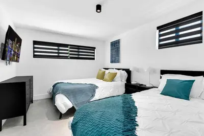 a bedroom with two beds and a flat screen tv at Heated Pool Modern 5 Bedrooms House 10 minutes to the Ocean in Miami