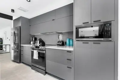 a kitchen with a refrigerator freezer and a microwave at Heated Pool Modern 5 Bedrooms House 10 minutes to the Ocean in Miami