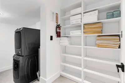 a room with a refrigerator and shelves with towels at Heated Pool Modern 5 Bedrooms House 10 minutes to the Ocean in Miami